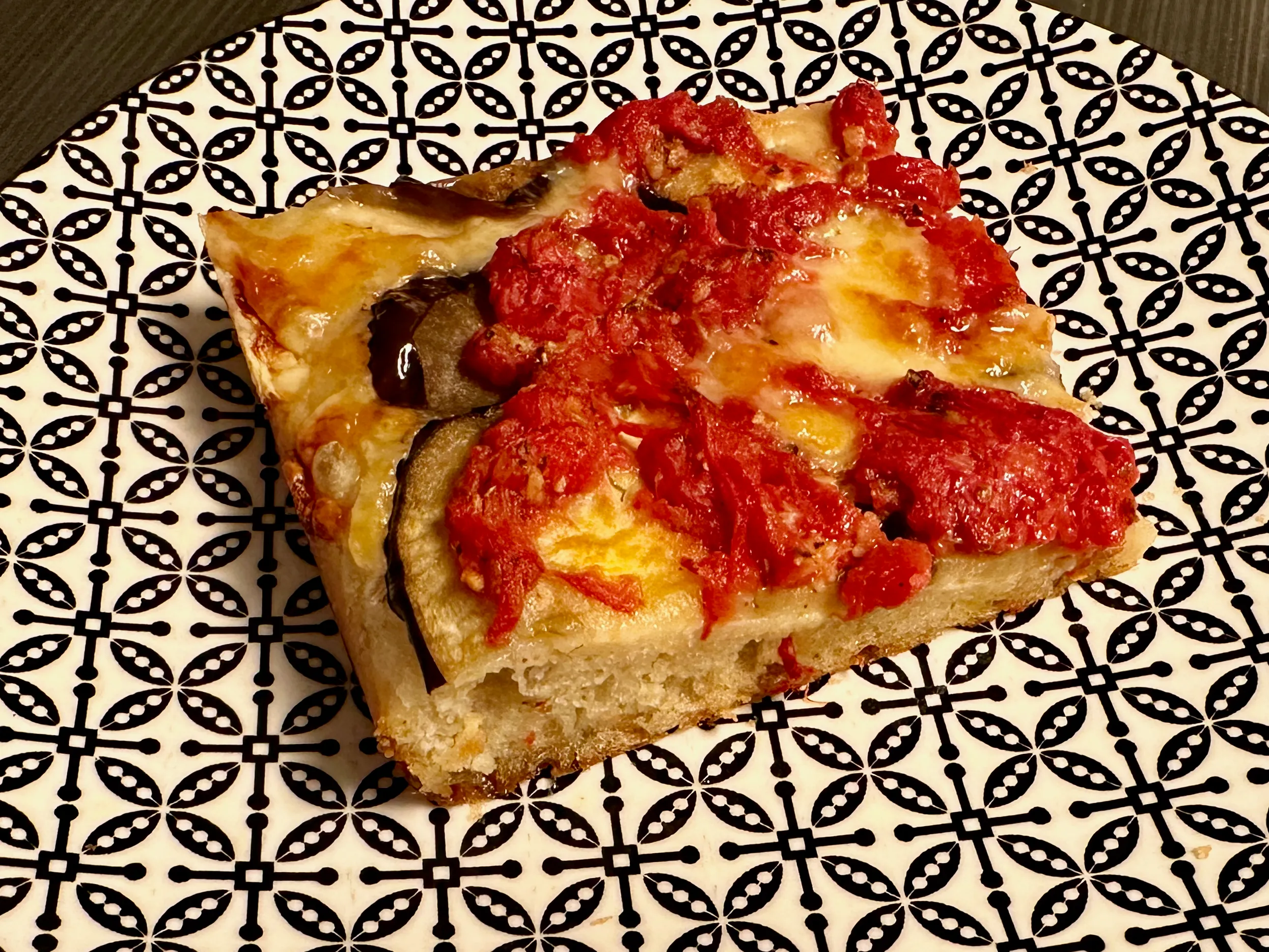 Grandma-style sheet pizza topped with eggplant and tomato sauce.